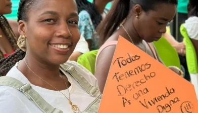 Fotos de viva mi casa donde podemos observar una mujer con un aviso naranja que dice todos tenemos derecho a una vivienda digna