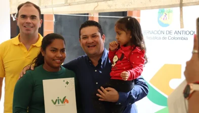 VIVA-NOTICIA-Gerente Foto de Gerente junto a beneficiaria de proyecto viva y su pequeña hija, cargada por el gerente