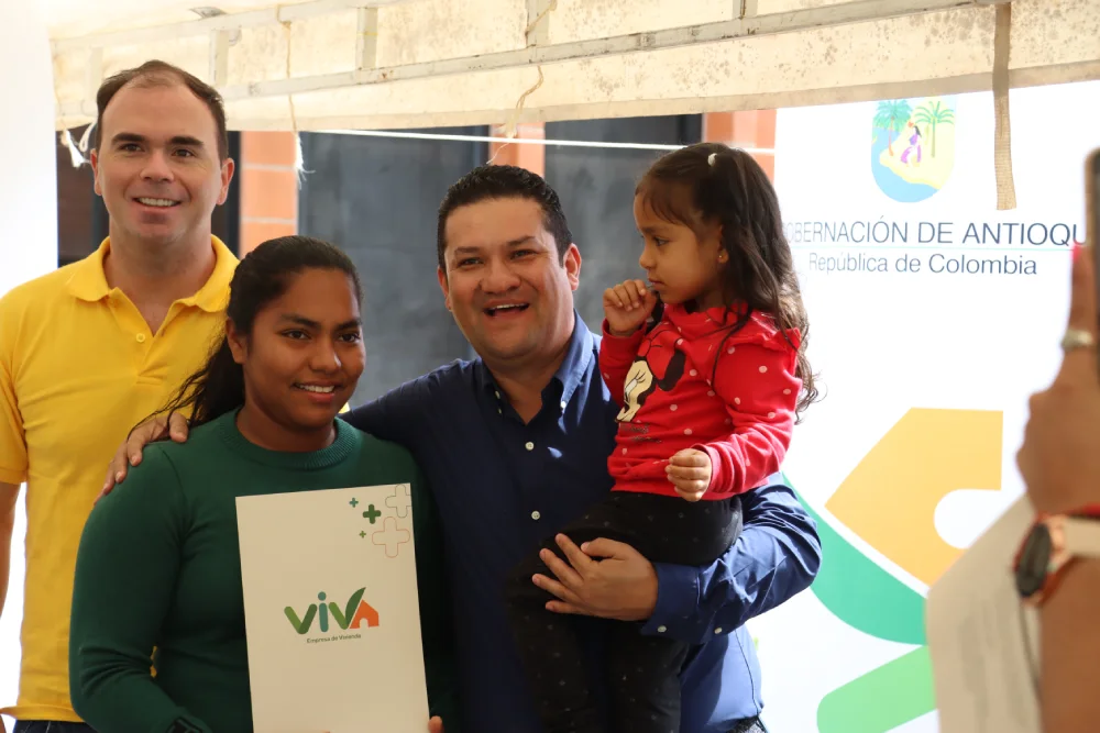 Foto de Gerente junto a beneficiaria de proyecto viva y su pequeña hija, cargada por el gerente